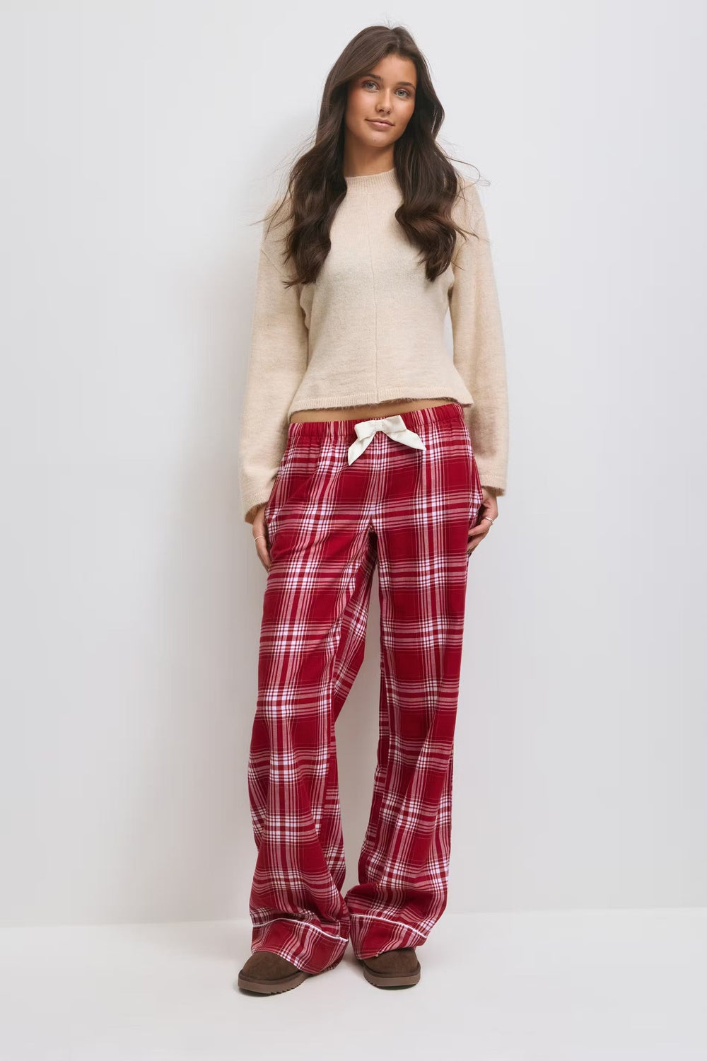 Crèmekleurige trui en rood geruite flanellen pyjamabroek met strik in de taille, vooraanzicht