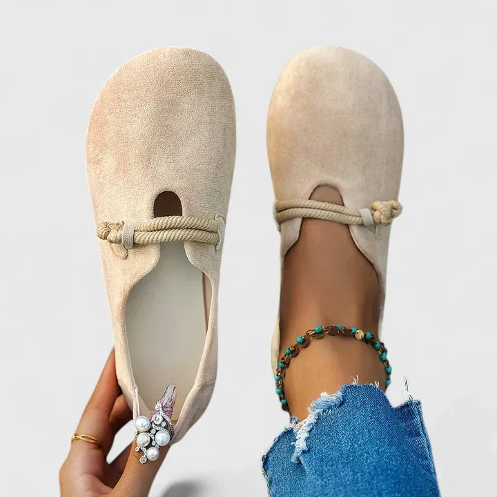 Beige instappers in suèdelook met koorddetail, in de hand en gedragen