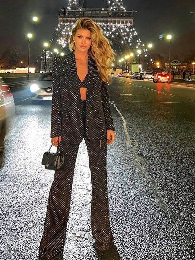 Driedelig glitterbroekpak: blazer met strass, bralette en flared broek in zwart, gedragen tijdens een avondje uit
