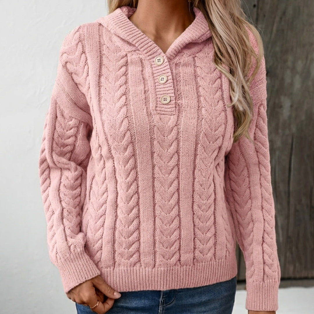 Vrouw in een roze kabeltrui met capuchon en knoopsluiting, met een jeans | Boutique Moda