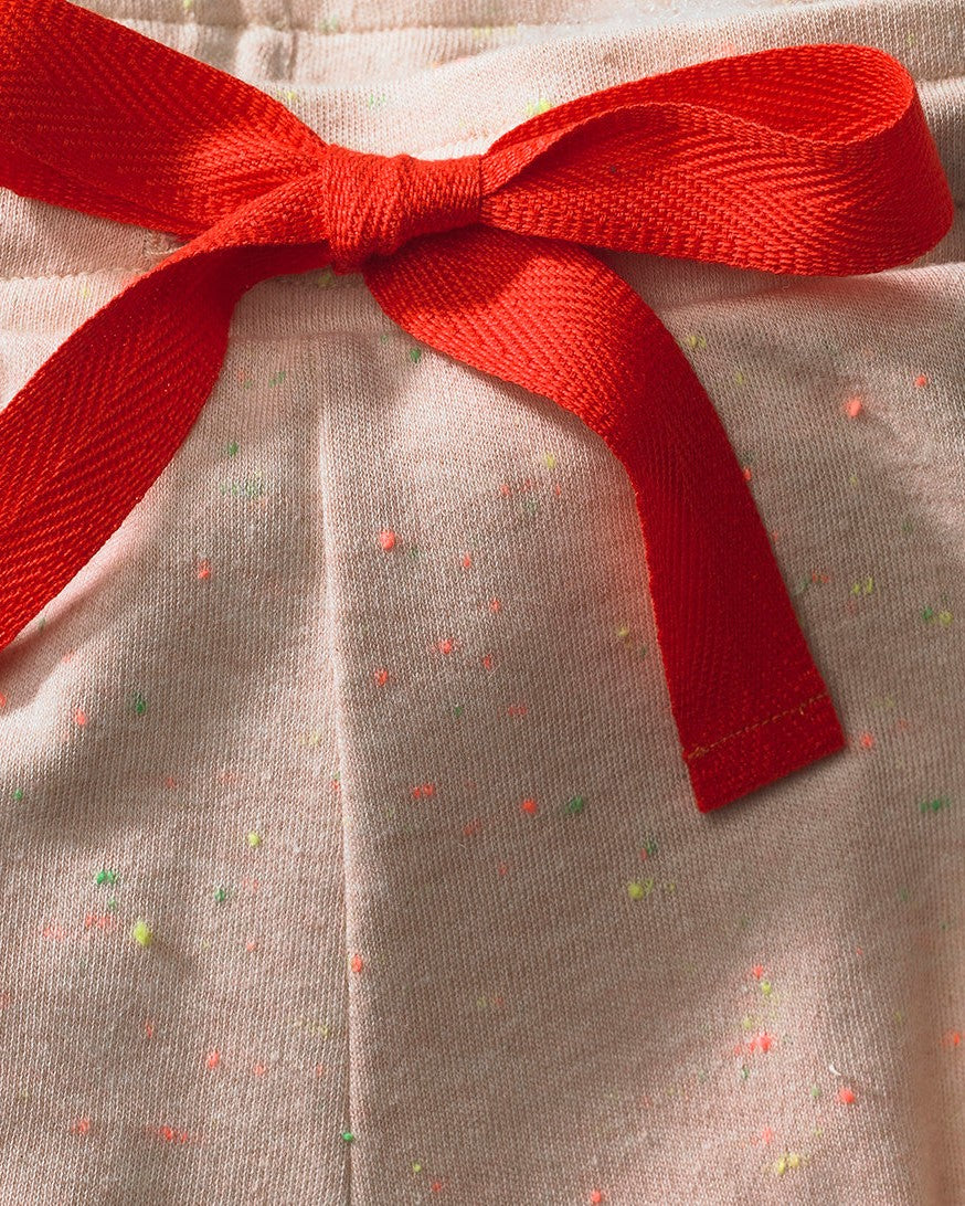 Rode strik en gekleurde spikkels van de havermoutkleurige pyjamabroek, close-up