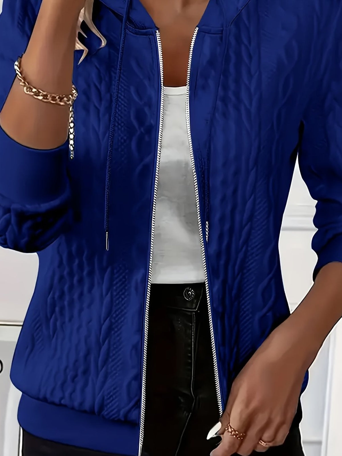 Vrouw draagt open koningsblauwe hoodie met rits en structuurpatroon over een wit topje | Boutique Moda
