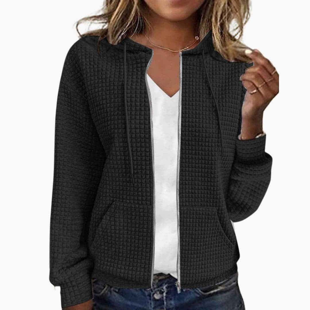 Vrouw in een zwart wafelvest, open gedragen over een wit T-shirt met V-hals | Boutique Moda