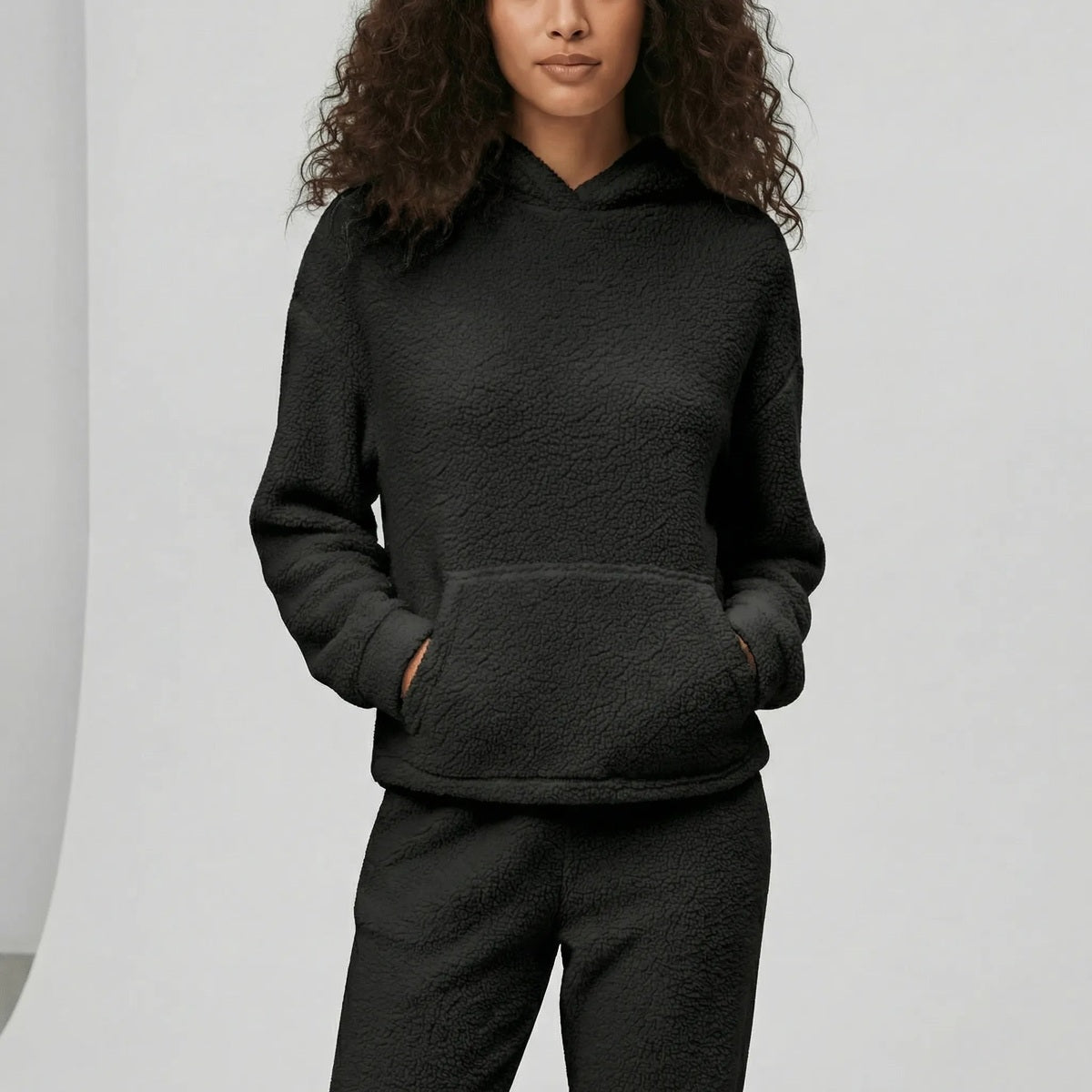 Huispak van teddyfleece in zwart, gedragen, vooraanzicht