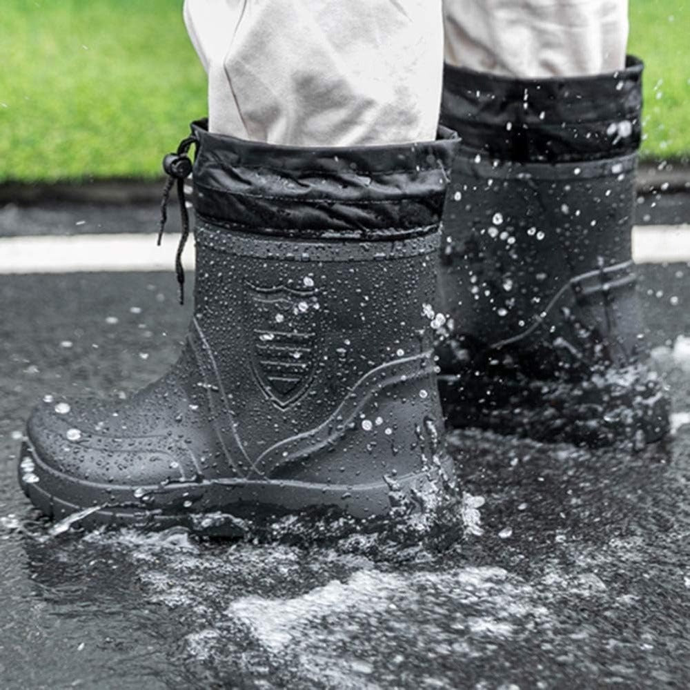 Gevoerde thermo-regenlaarzen voor heren in zwart, gedragen in een plas
