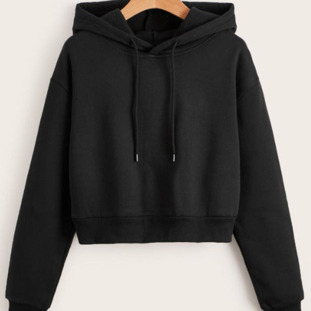 Zwarte cropped hoodie aan een kleerhanger, met koorden en geribde zoomband | Boutique Moda
