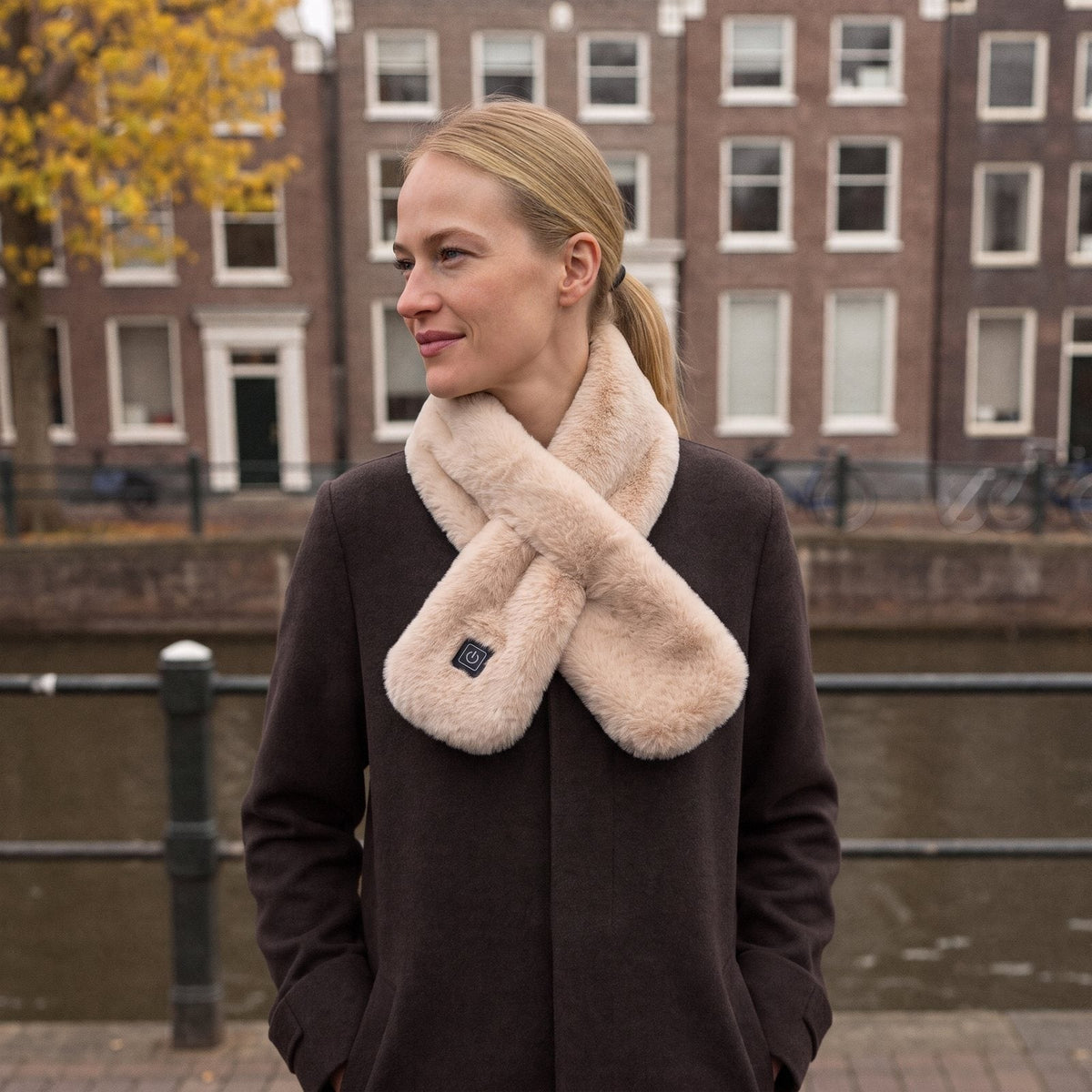 Vrouw aan de gracht met de verwarmde sjaal in champagne om haar hals