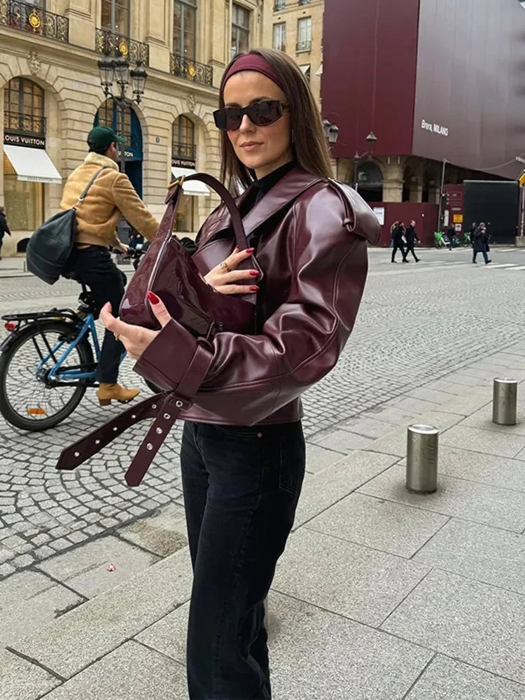 Kort jasje van imitatieleer voor dames in bordeaux met een brede reverskraag, gedragen, zijaanzicht met de riem