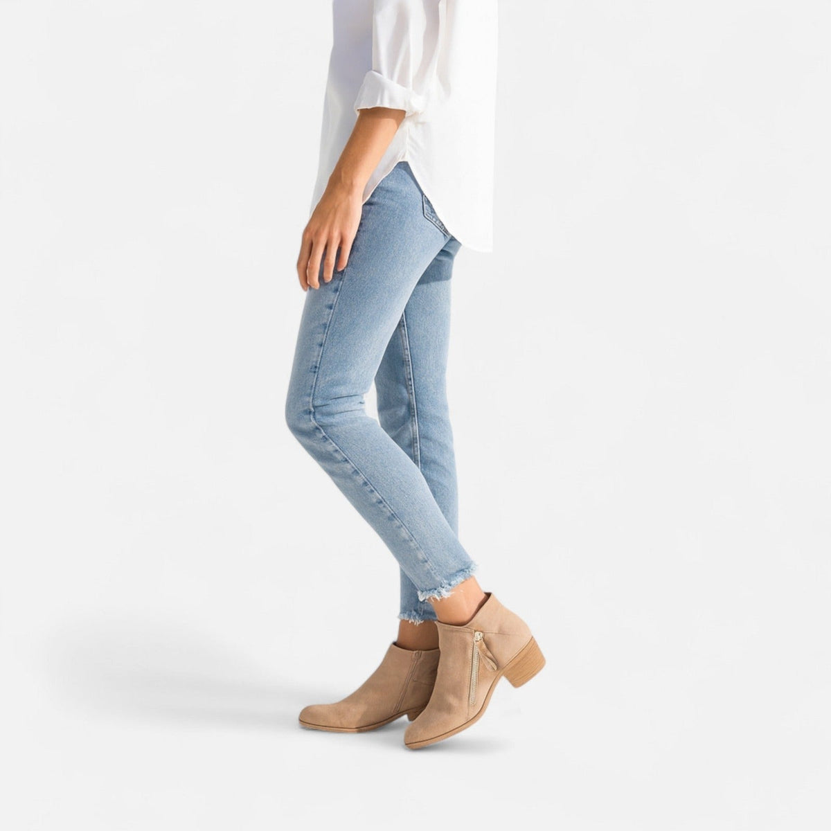 Beige laarsjes met blokhak onder een lichte jeans, zijaanzicht