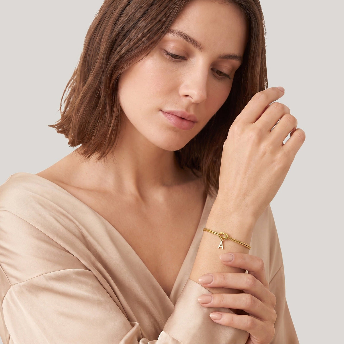 Vrouw draagt de gouden initiaal armband