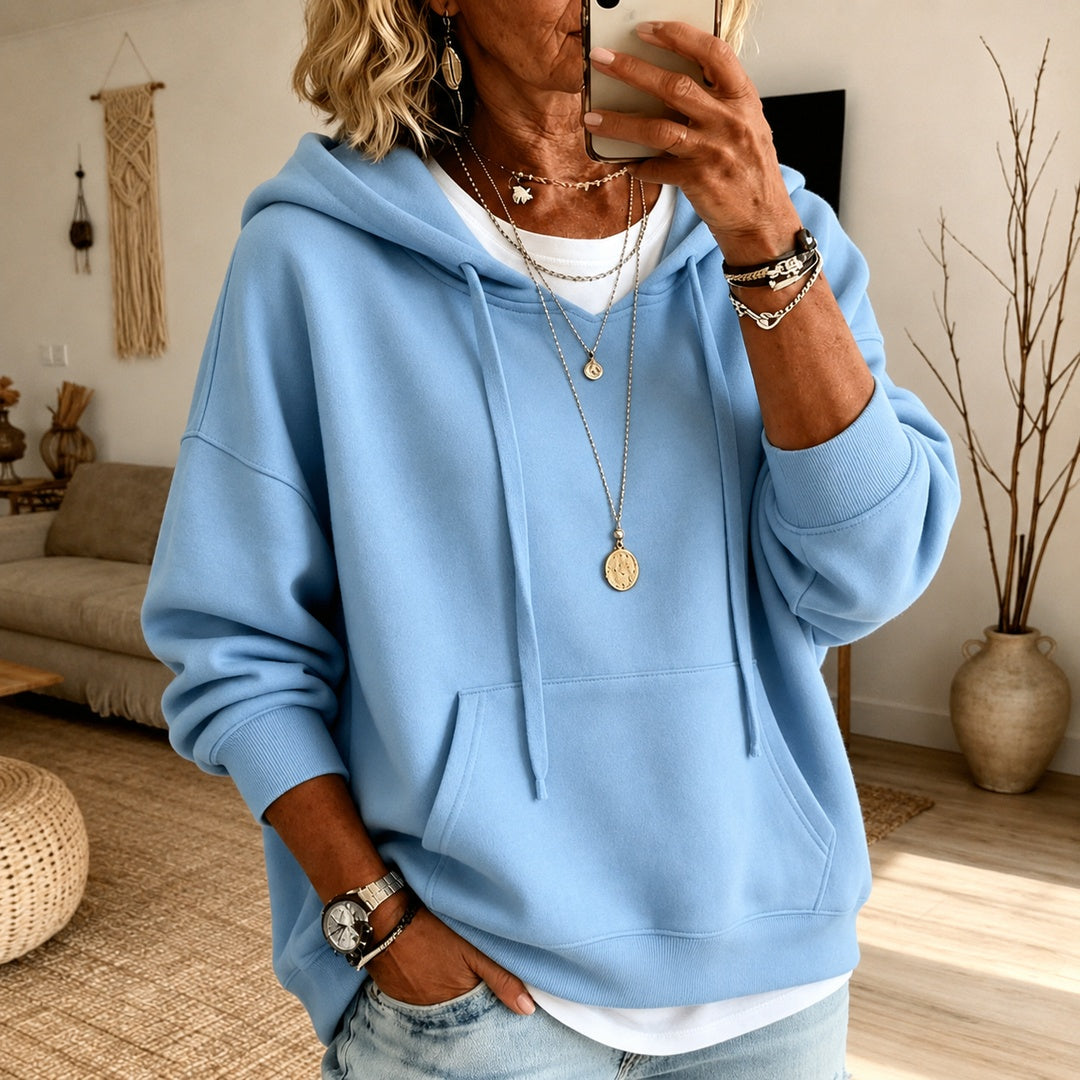 Vrouw in een hemelsblauwe oversized trui met koorden en kangoeroezak | Boutique Moda