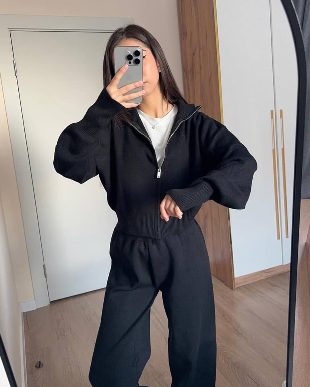 Gebreide set in zwart met ritsvest en wijde broek, spiegelfoto