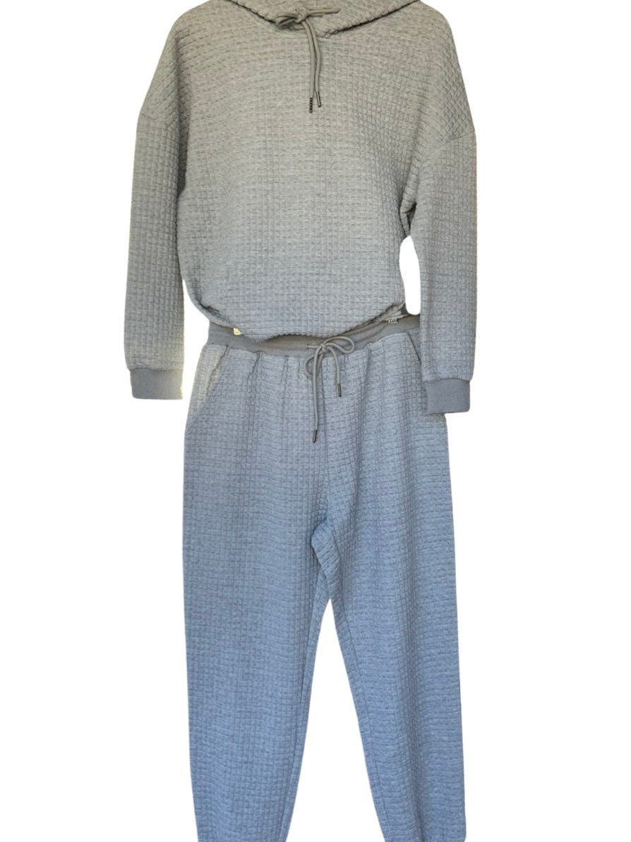 Joggingpak met wafelstructuur in grijs, hoodie met koord en joggingbroek aan een hanger
