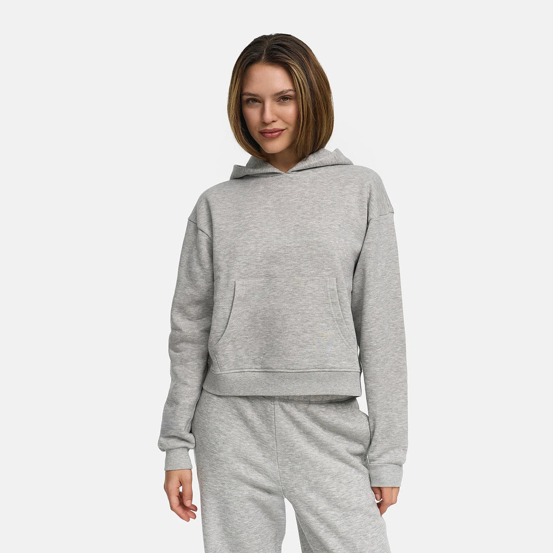 Vrouw in een lichtgrijs gemêleerde sweater met capuchon en geribde boorden | Boutique Moda