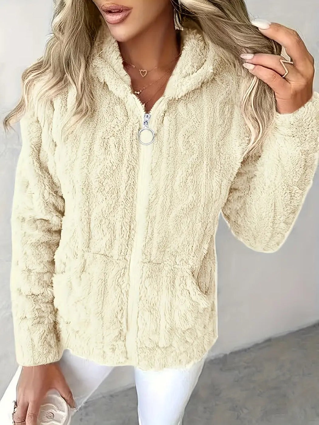 Vrouw draagt een beige teddyvest met capuchon en kabelpatroon, gesloten | Boutique Moda