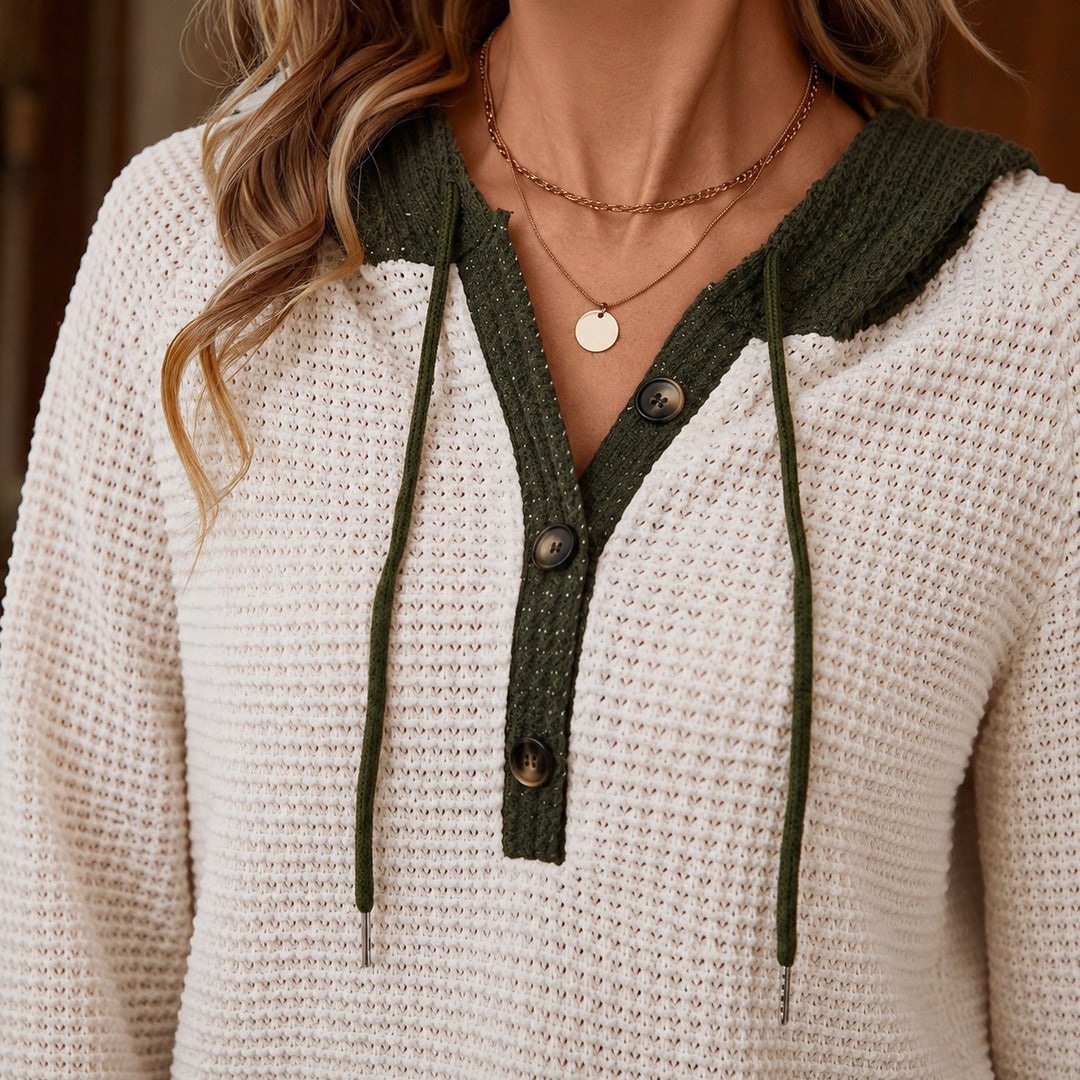 Close-up van de beige capuchontrui: olijfgroene capuchon, knoopsluiting met bruine knopen en koorden | Boutique Moda
