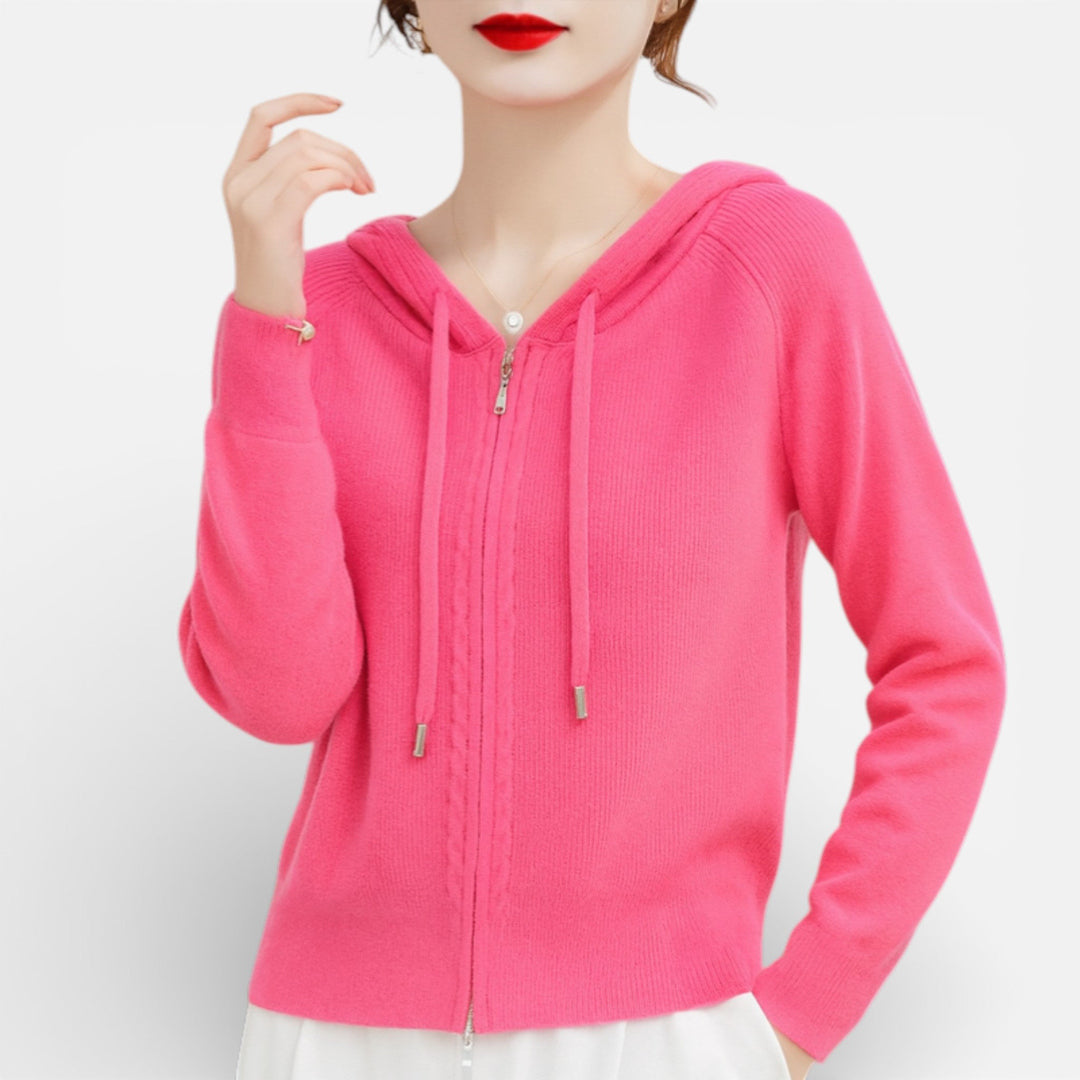 Vrouw draagt een roze gebreid vest met capuchon en koorden, hand omhoog | Boutique Moda