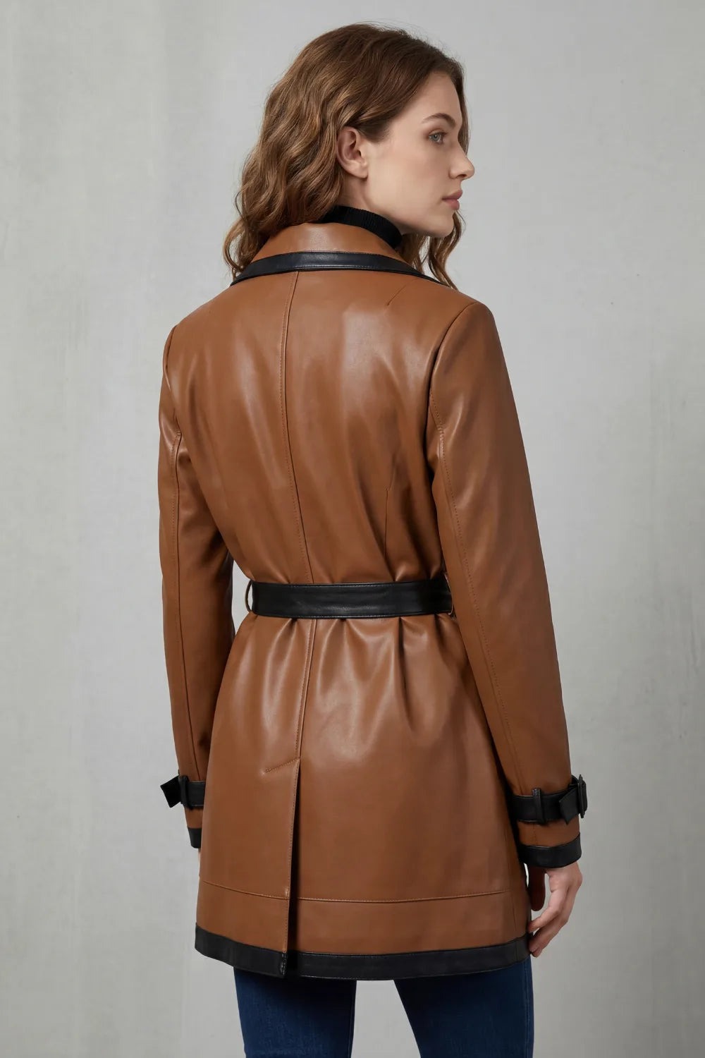 Trenchcoat dames van imitatieleer in bruin met zwarte strikceintuur, gedragen, achterkant