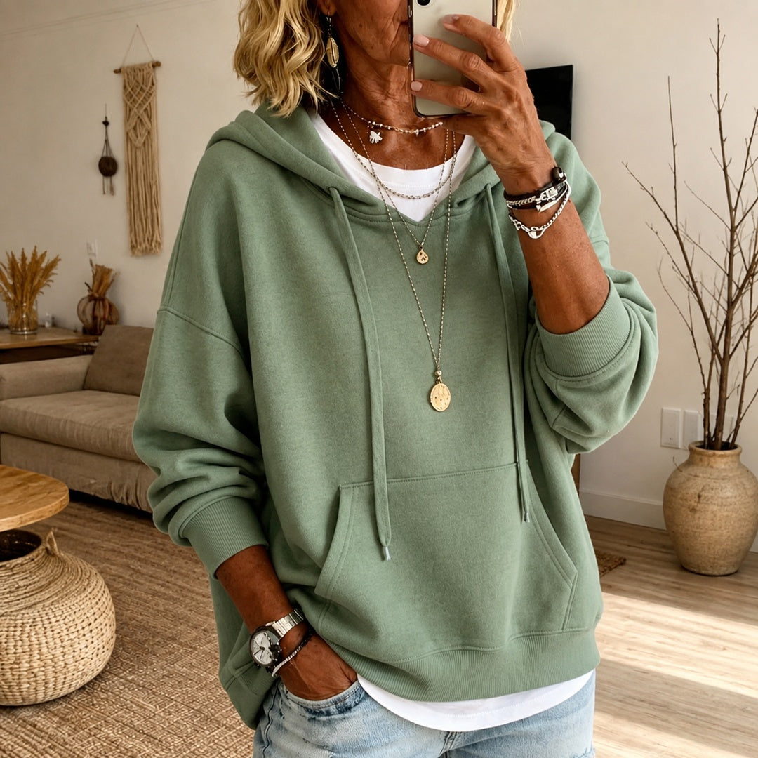 Vrouw in een saliegroene oversized trui met geribde boorden, hand in de broekzak | Boutique Moda