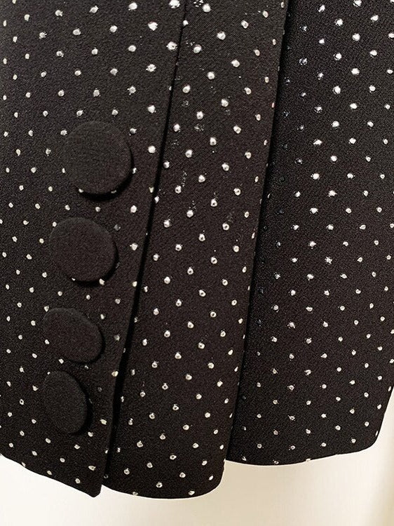 Driedelig glitterbroekpak: blazer met strass, bralette en flared broek in zwart, close-up van de manchet met knopen
