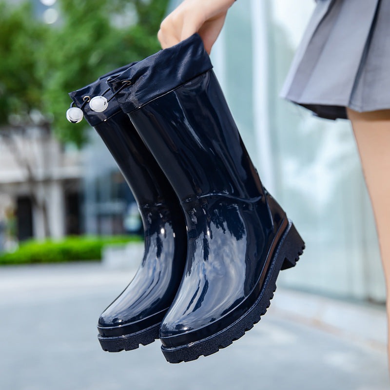 Regenlaarzen met stoffen schacht en koord in marineblauw, in de hand gehouden