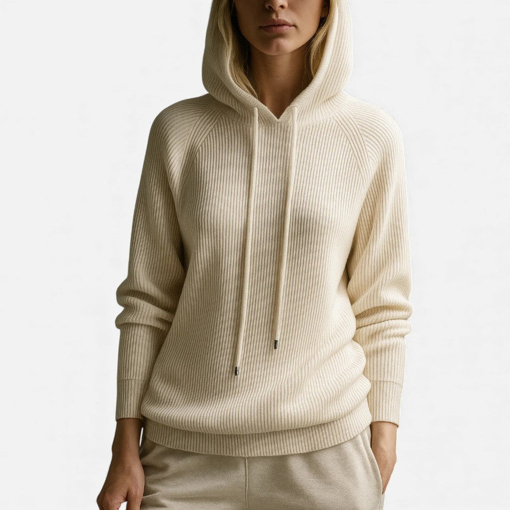 Vrouw met opgezette capuchon in een gebroken witte hoodie en een lichte broek | Boutique Moda