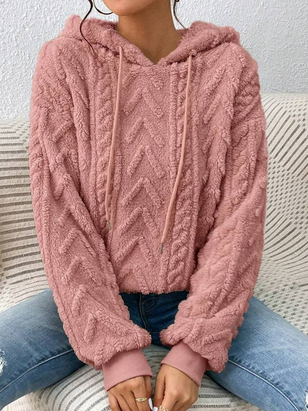 Vrouw in een roze teddytrui met zigzagmotief in reliëf en geribde boorden | Boutique Moda