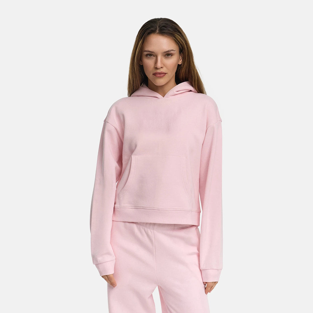Vrouw in een lichtroze sweater met kangoeroezak en verlaagde schouders | Boutique Moda