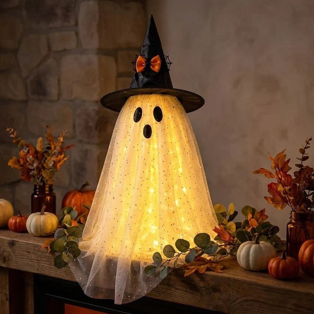 Lichtgevend spookje met heksenhoed op een schoorsteenmantel