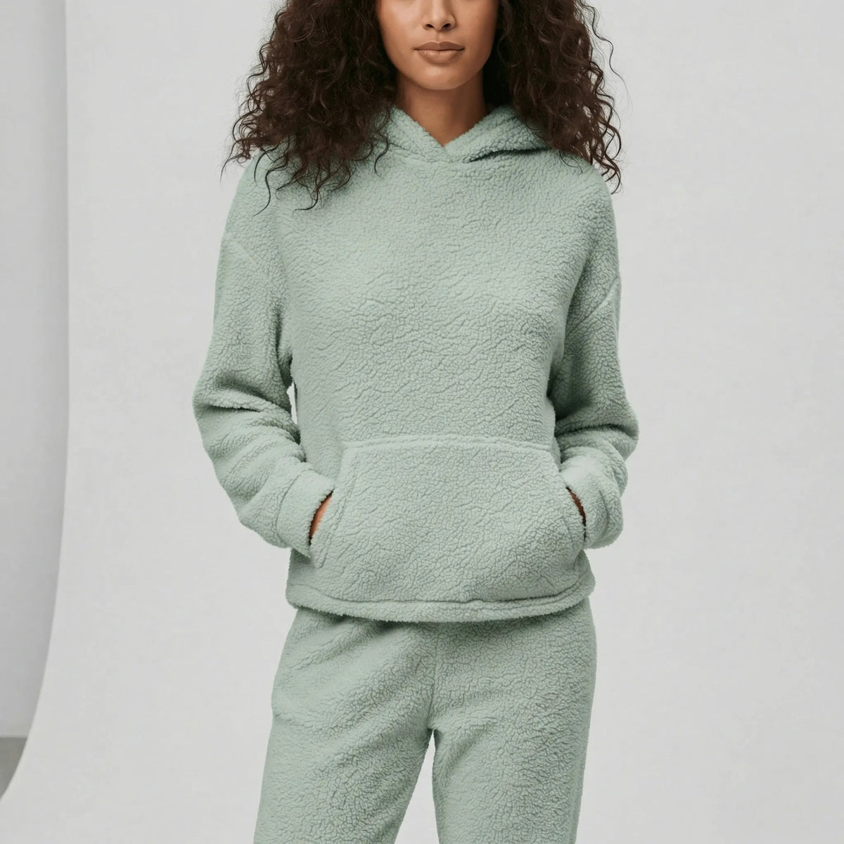 Huispak van teddyfleece in saliegroen, gedragen, vooraanzicht