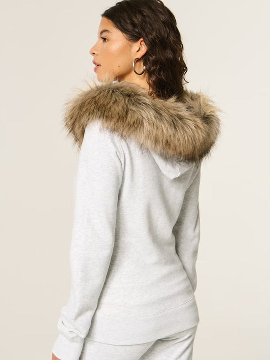 Achteraanzicht van de lichtgrijze hoodie met pluizige nepbontrand aan de capuchon | Boutique Moda