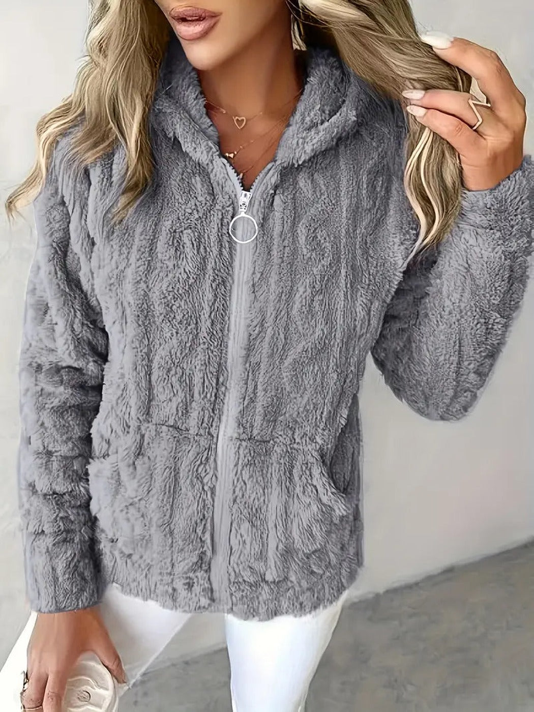 Vrouw draagt een grijs teddyvest met pluizig kabelpatroon en zilveren ringtrekker | Boutique Moda