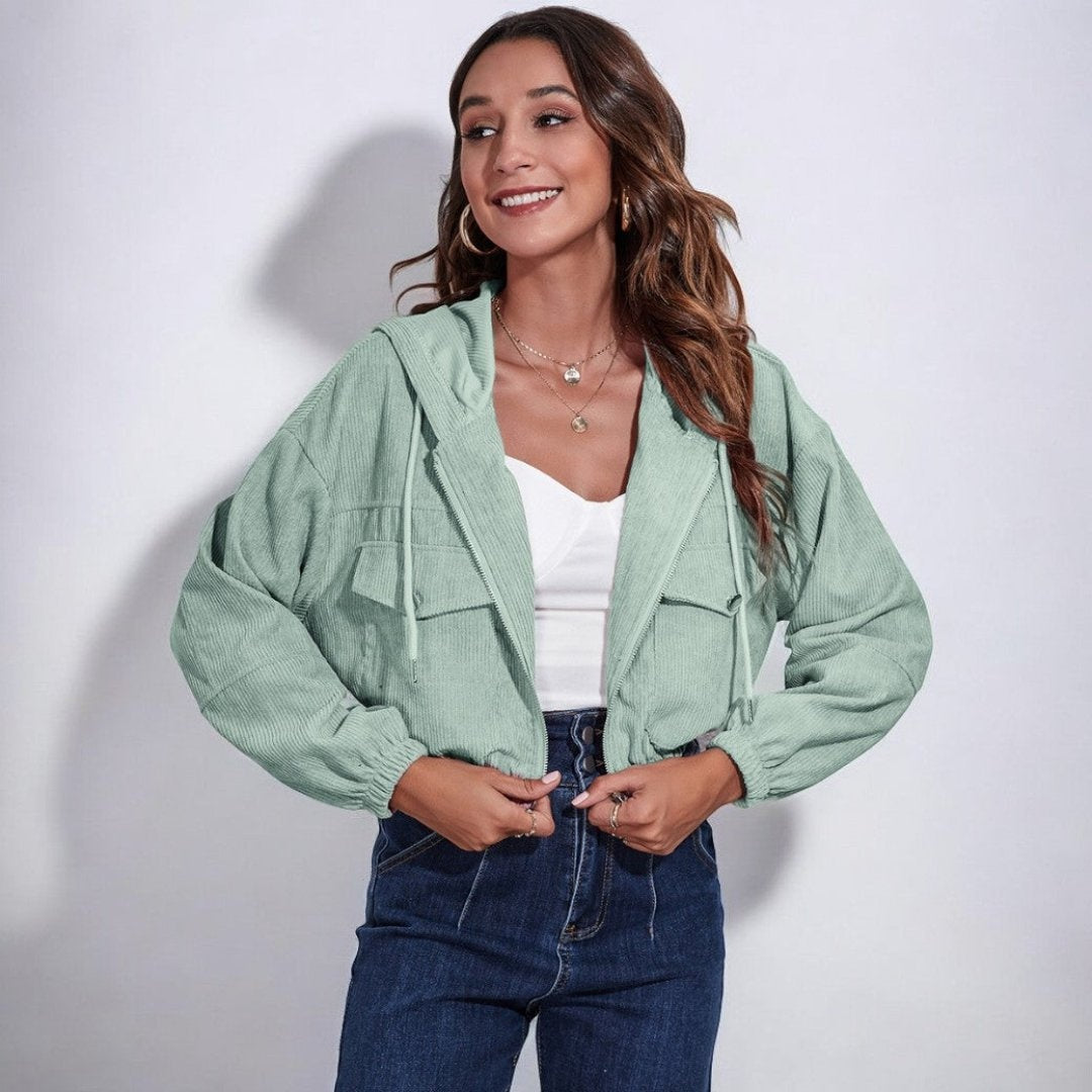 Vrouw draagt korte mintgroene corduroy jas met capuchon over een wit topje | Boutique Moda