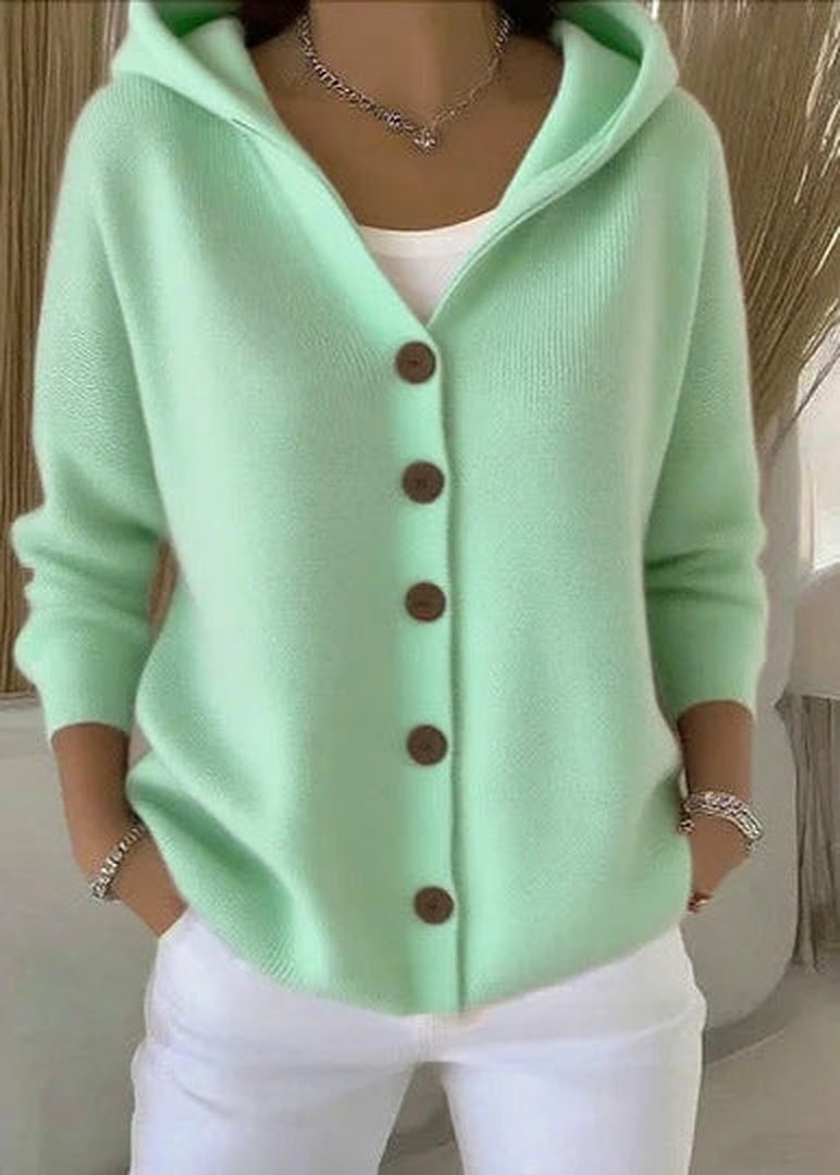 Mintgroen gebreid capuchonvest met knoopsluiting, gedragen door een vrouw, witte broek | Boutique Moda