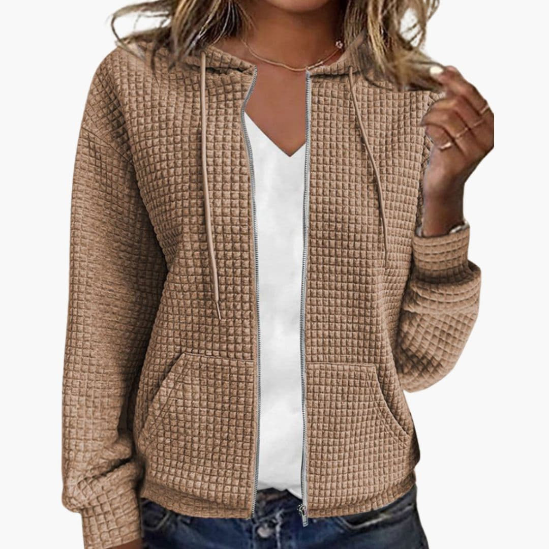 Vrouw in een khaki wafelvest, open over een wit T-shirt, met een jeans | Boutique Moda