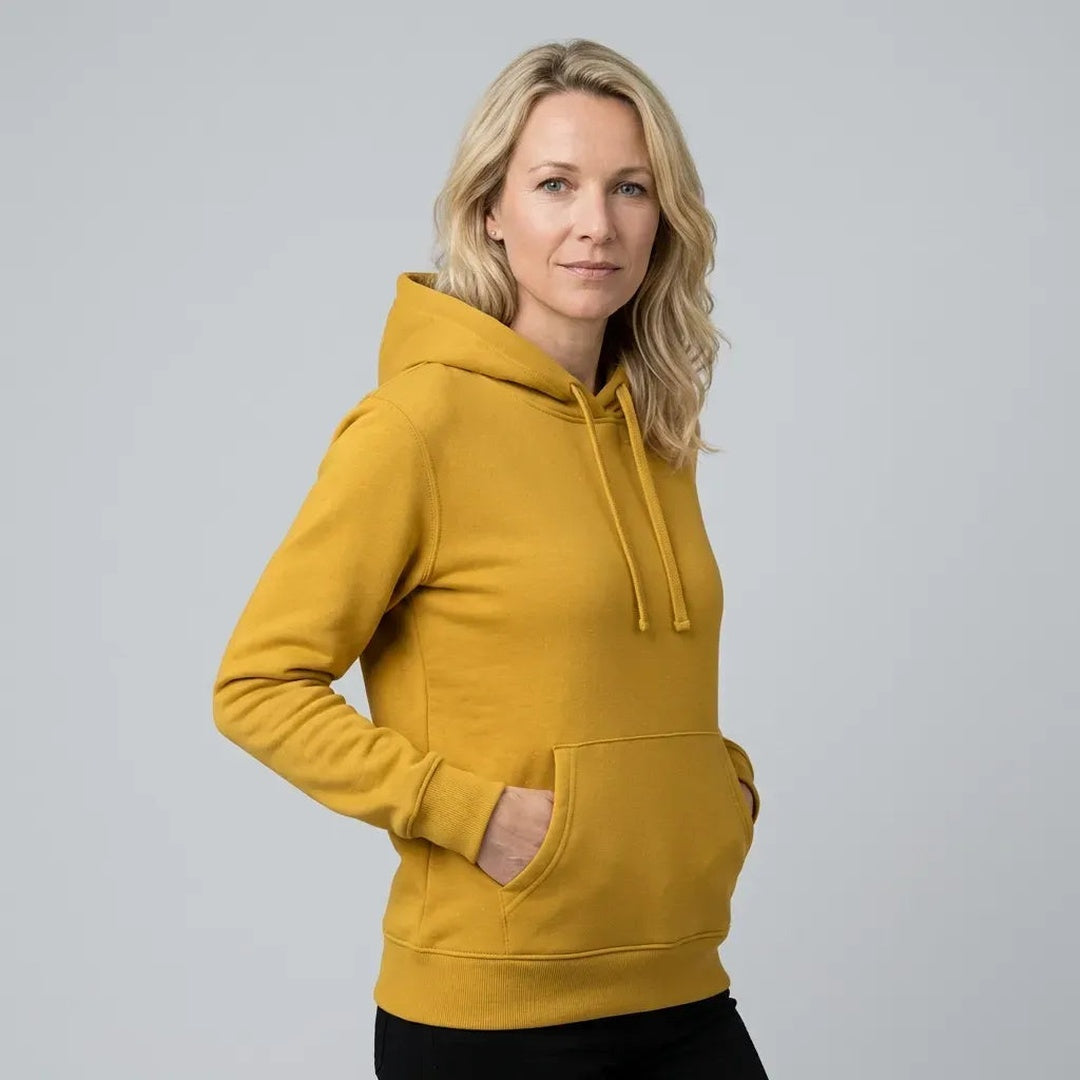 Vrouw draagt mosterdgele hoodie met koorden en kangoeroezak | Boutique Moda