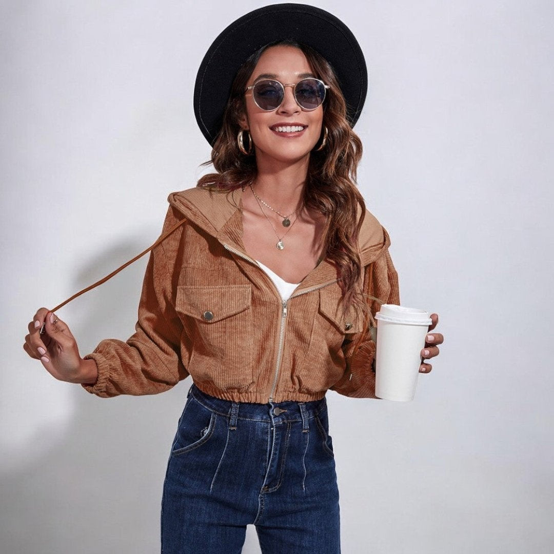 Vrouw draagt korte bruine corduroy jas met hoed, zonnebril en koffiebeker | Boutique Moda