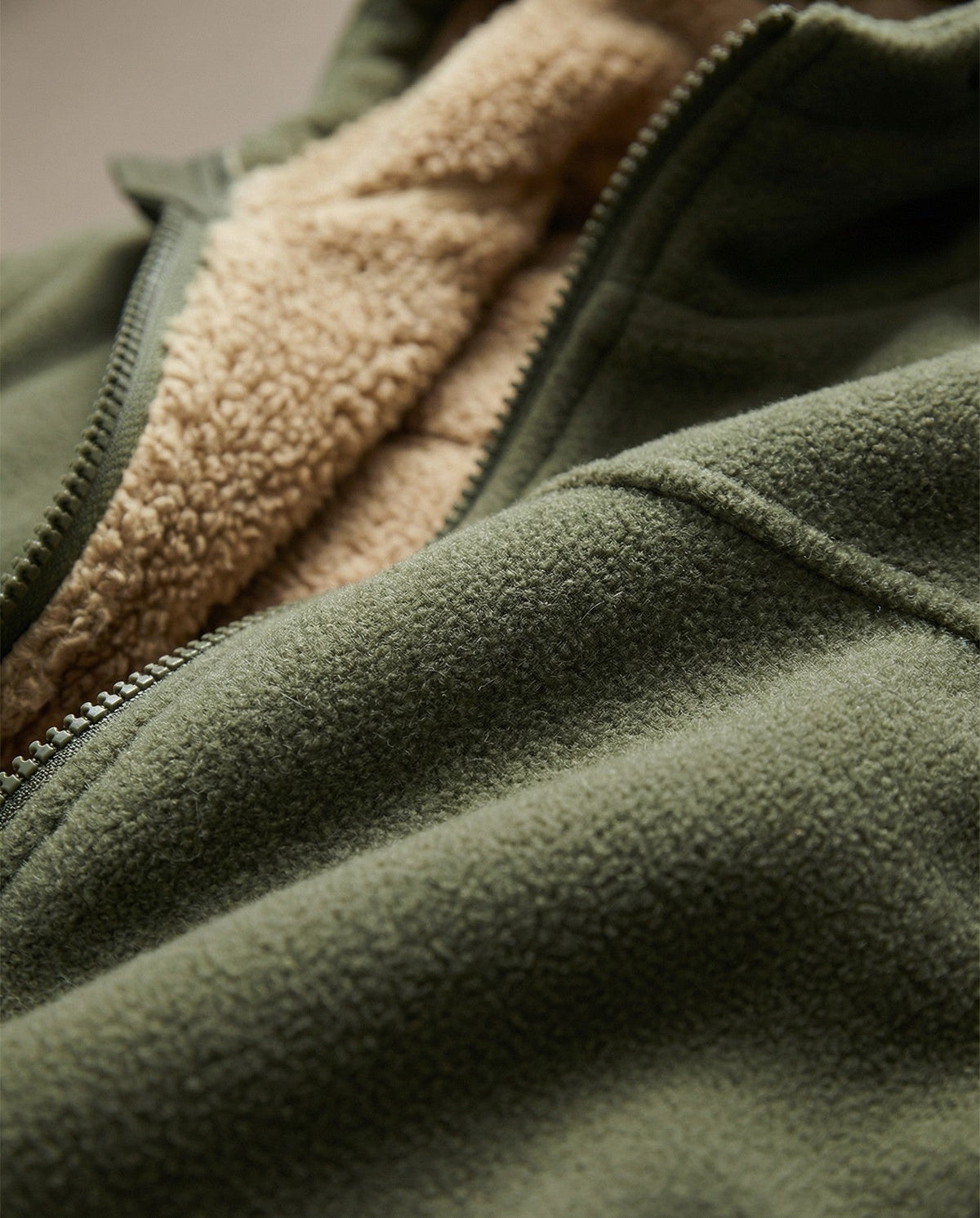 Gevoerd fleecevest met capuchon voor heren in legergroen, close-up van de teddyvoering en de rits