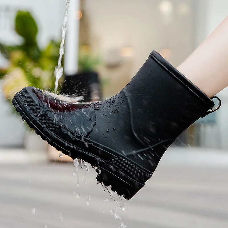 Lage matte regenlaarzen in zwart, gedragen onder een waterstraal