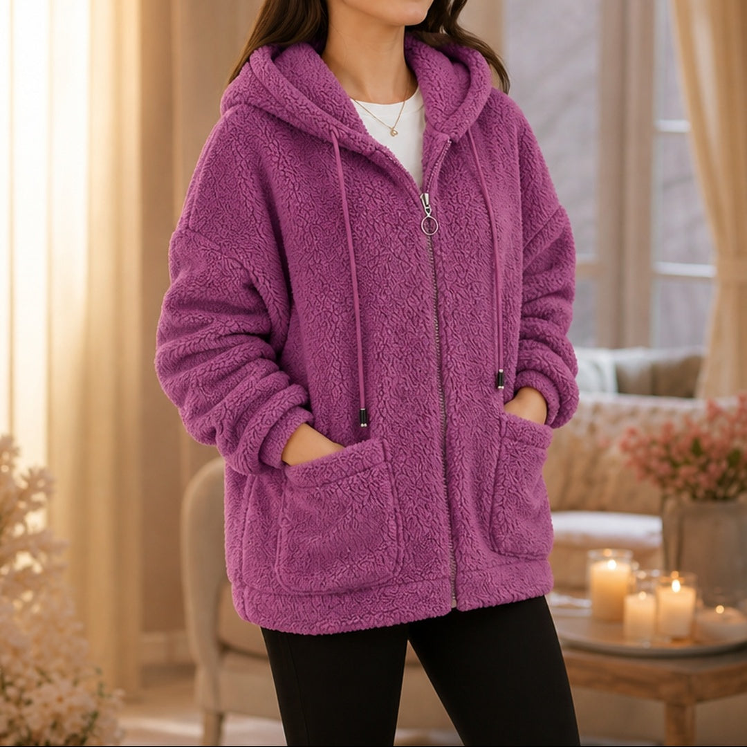 Vrouw in een magenta teddyvest met capuchon en koorden, handen in de zakken | Boutique Moda