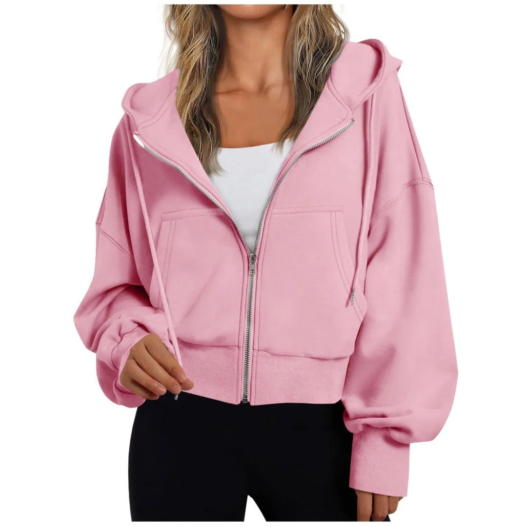 Vrouw in een roze vest met verlaagde schouders over een wit topje | Boutique Moda
