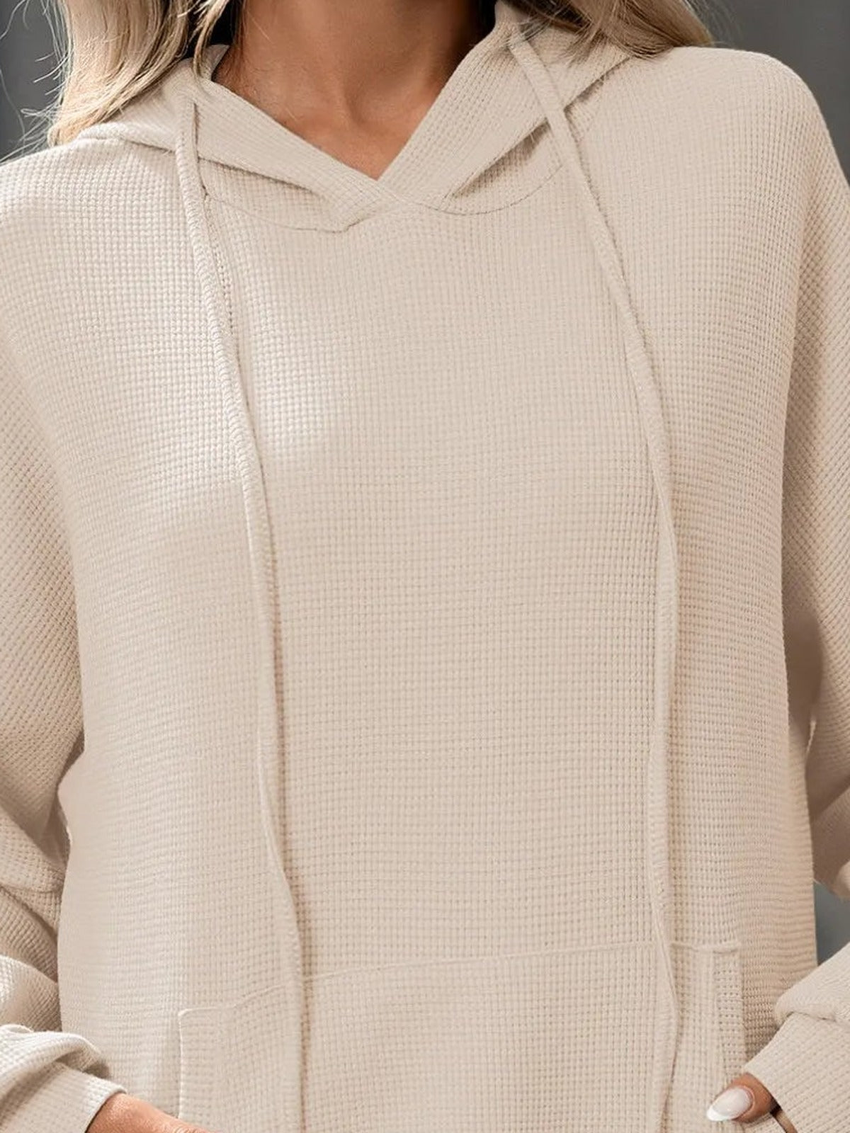 Close-up van de beige sweater: hals, koorden en wafelstructuur | Boutique Moda