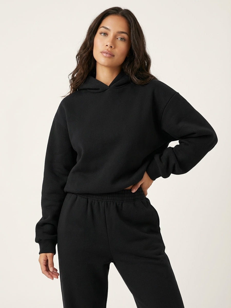 Oversized hoodie en joggingbroek in zwart, hand op de heup