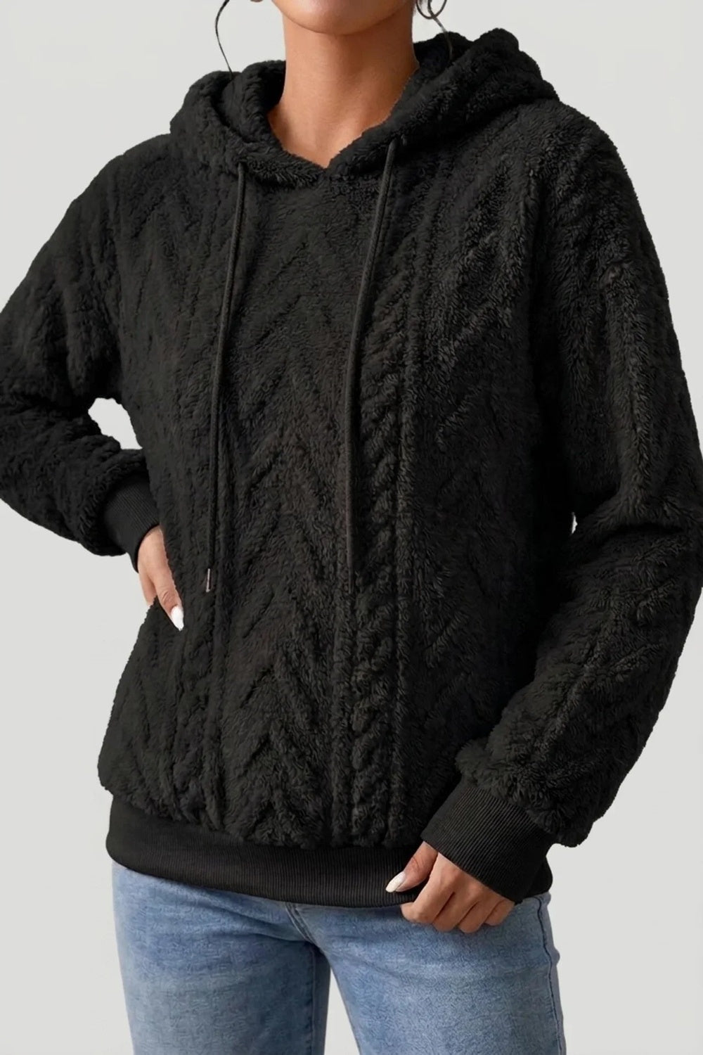 Vrouw in een zwarte teddytrui met koorden, hand op de heup | Boutique Moda