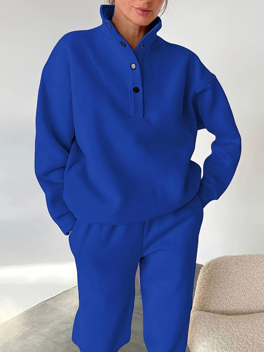 Kobaltblauwe sweater met knopen aan de opstaande kraag, close-up