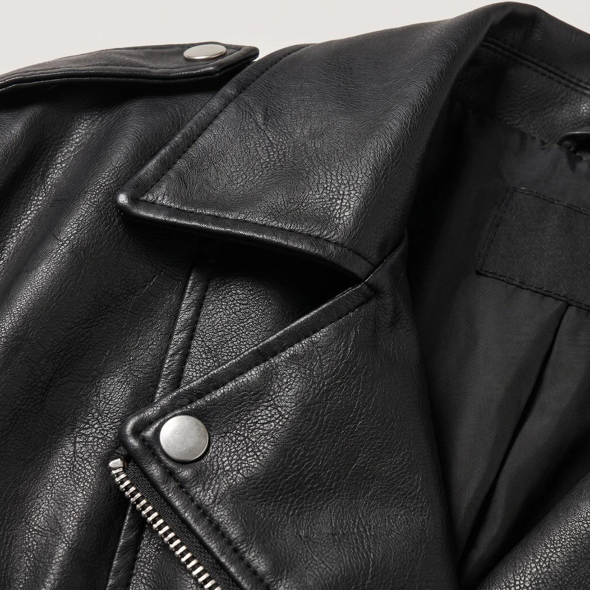 Bikerjack in leerlook met riem in zwart, close-up van kraag en rits