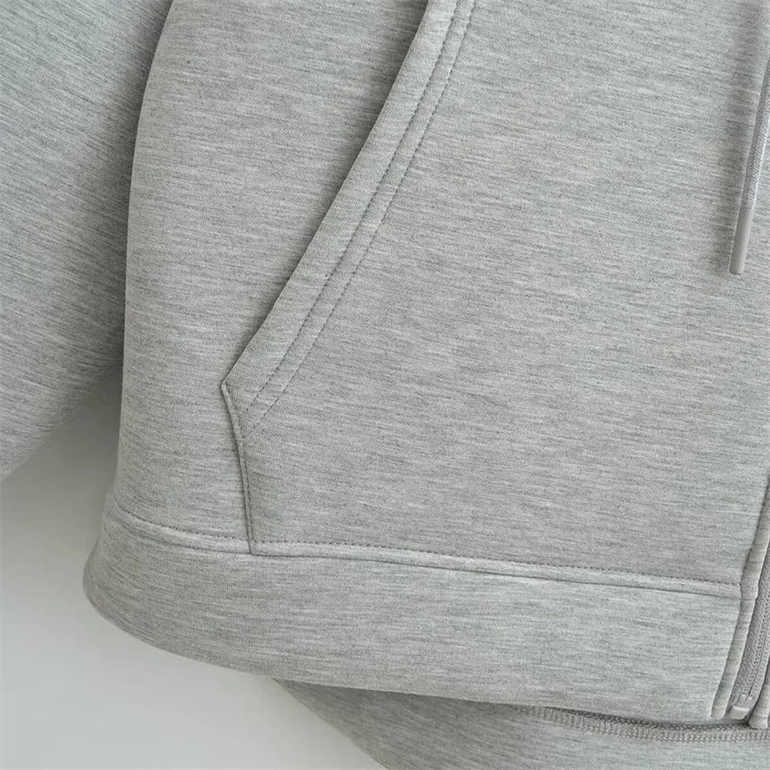 Close-up van een zak en de zoomband van het lichtgrijze vest | Boutique Moda