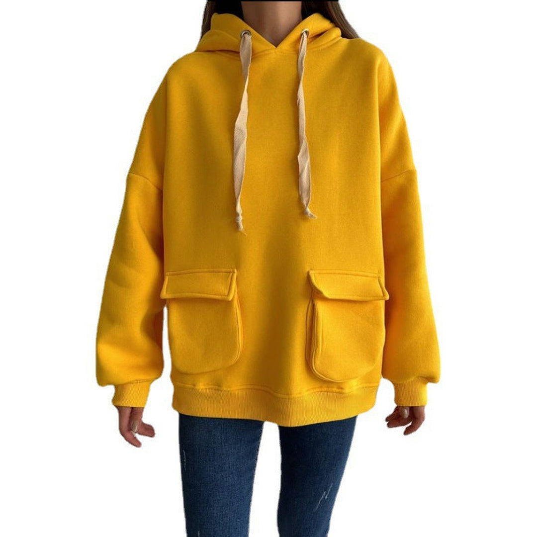 Vrouw in een mosterdgele oversized hoodie met extra lange koorden en geribde boorden, op een witte achtergrond | Boutique Moda