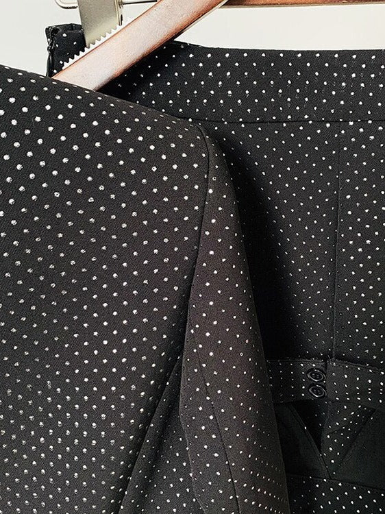 Driedelig glitterbroekpak: blazer met strass, bralette en flared broek in zwart, close-up van de blazerschouder en de tailleband van de broek