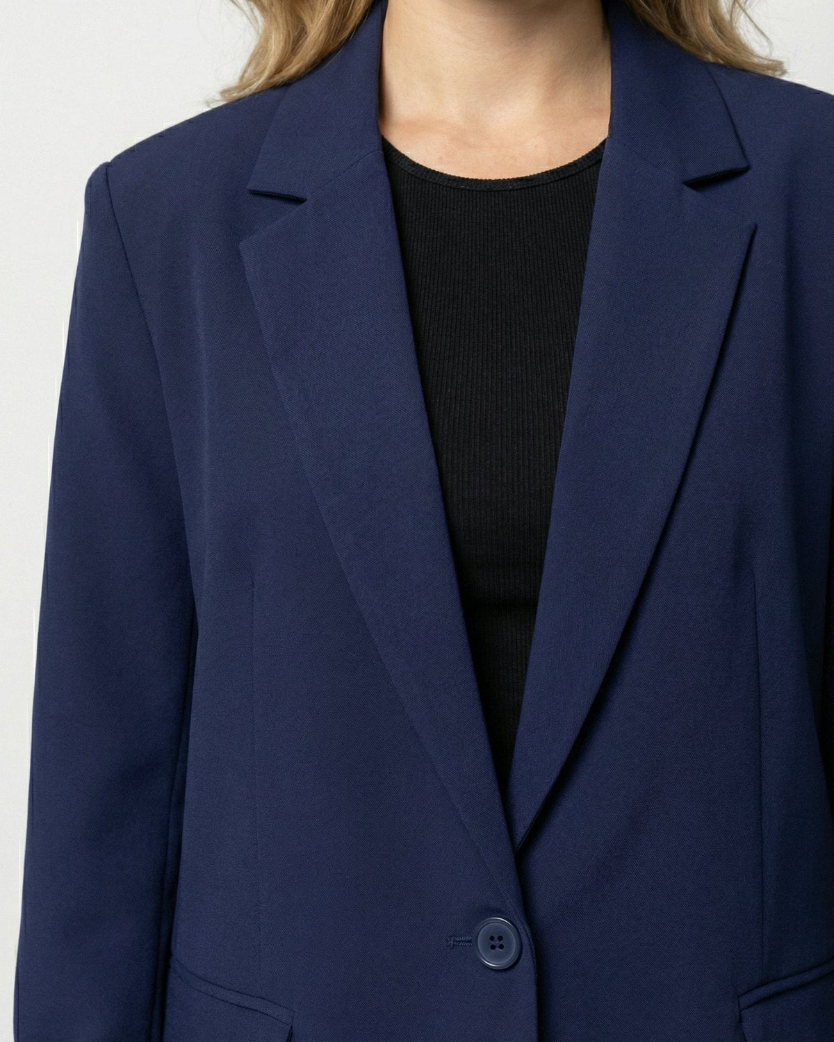 Tweedelig pak met getailleerde blazer en wijde broek in marineblauw, close-up van revers en knoop